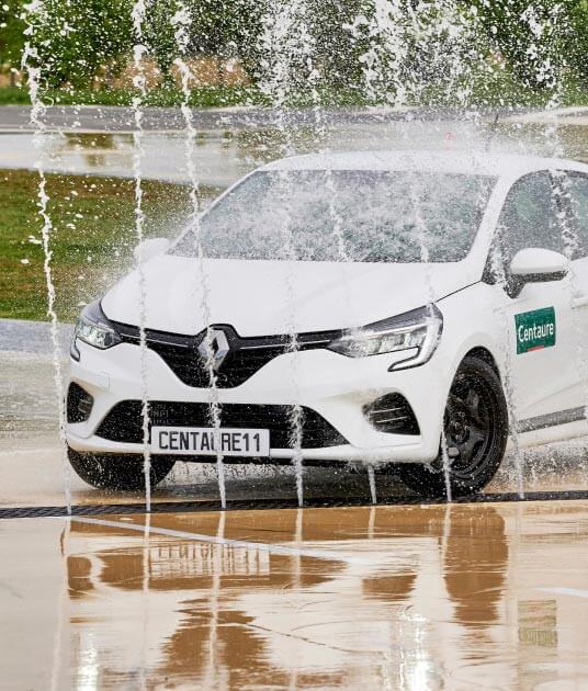 Voiture Renault Clio en stage de conduite sur des jets d'eau